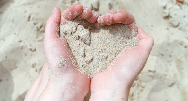 Kinderhände, Herzs aus Sand